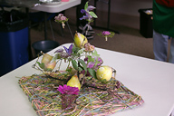 An arrangement for a table with waxed fruits and flowers